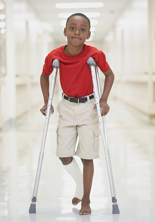 young boy on crutches